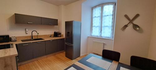 une cuisine avec un réfrigérateur, une table et une fenêtre dans l'établissement L'Arbre Rose de Bergheim, à Bergheim