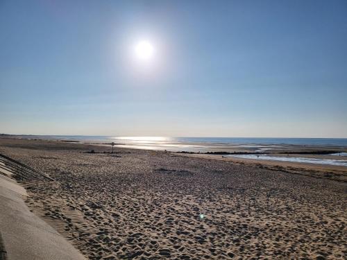 - une plage au soleil se levant au-dessus de l'océan dans l'établissement Appartement à 300 m de la mer, à Cabourg