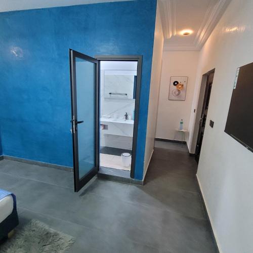 a bathroom with a blue wall and a mirror at Chambres d'hôtes saly in Saly Portudal