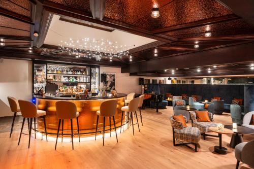 a bar in a restaurant with chairs and a bar counter at Resort La Ginabelle in Zermatt