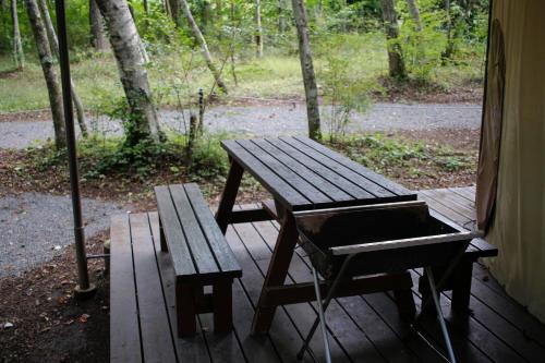 a picnic table and a bench on a porch at PICA Fujiyoshida in Fujiyoshida