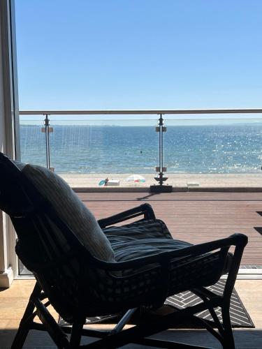 a chair in a room with a view of the ocean at Ostsee-Strandhaus-Holnis in Glücksburg