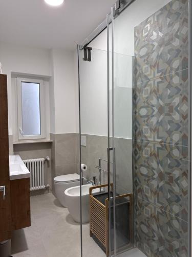 baño con aseo y puerta de ducha de cristal en Ambra Central Park - Giulia 19, en Trieste
