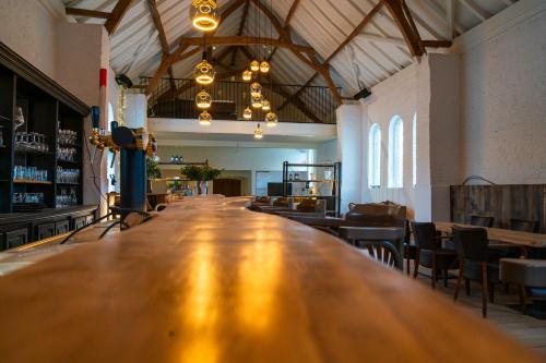 a long wooden bar in a large room with chairs at Barabois luxury vacation home in Ronse