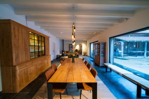 a long wooden table in a room with chairs at Barabois luxury vacation home in Ronse