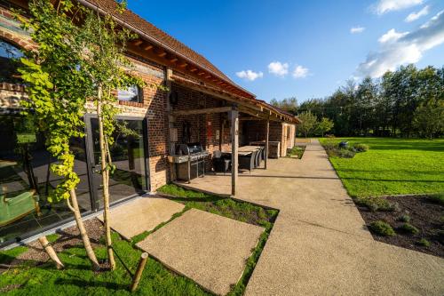 a brick house with a walkway next to a building at Barabois luxury vacation home in Ronse