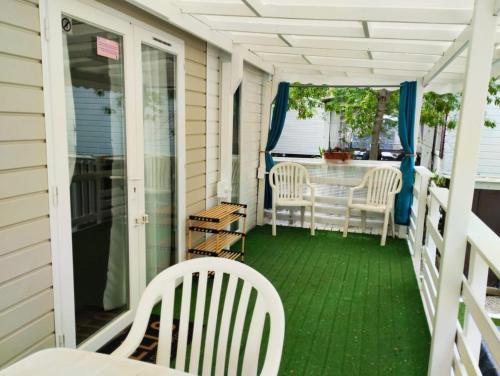 une terrasse couverte avec une table et des chaises. dans l'établissement Mobil-home CA 67 à Vias - La Carabasse - Camping Siblu avec piscine, à Vias