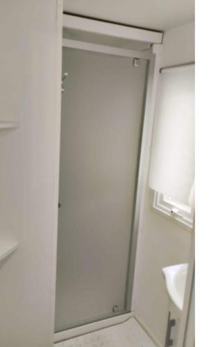 une salle de bain avec une douche avec une porte vitrée dans l'établissement Mobil-home CA 67 à Vias - La Carabasse - Camping Siblu avec piscine, à Vias