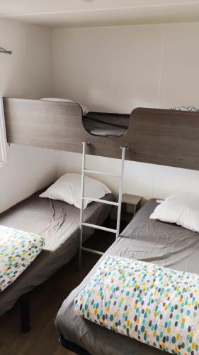 Ce lit se trouve dans un dortoir doté de lits superposés. dans l'établissement Mobil-home CA 67 à Vias - La Carabasse - Camping Siblu avec piscine, à Vias