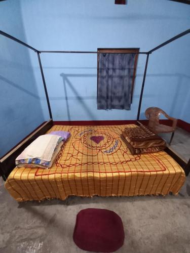 a small bed in a room with a blue wall at Backpacker Homestay in Siliguri