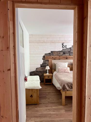 une chambre avec un lit et un mur en pierre dans l'établissement Gîte 2 à 8 personnes style chalet avec garage privé et jardin, à La Bresse
