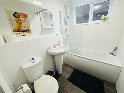 a white bathroom with a toilet and a sink at Luton Parkway Apartment-4 guests- free parking in Luton