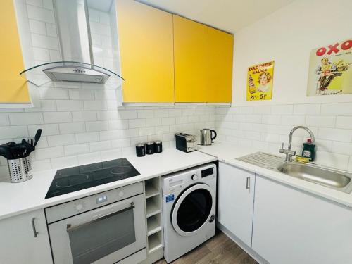 a kitchen with a sink and a washing machine at Luton Parkway Apartment-4 guests- free parking in Luton