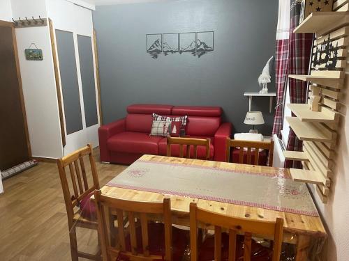 un salon avec un canapé rouge et une table dans l'établissement Appartement F2 La Bresse, à La Bresse