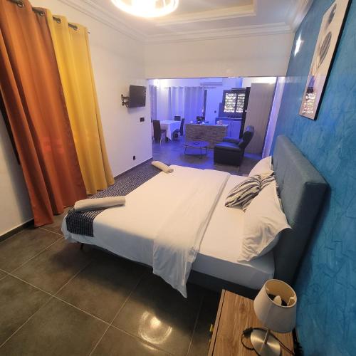 a bedroom with a large bed and a living room at Studio à louer dans une maison d hôtes in Saly Portudal