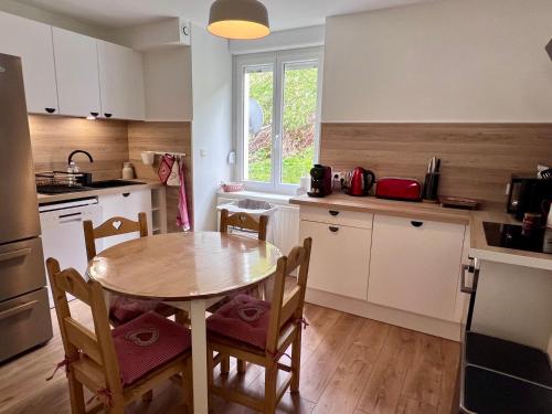 une cuisine avec une table et des chaises dans une pièce dans l'établissement Gîte 2 à 8 personnes style chalet avec garage privé et jardin, à La Bresse