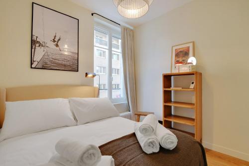 une chambre avec un lit avec des serviettes dessus dans l'établissement Parisian Suites, à Boulogne-Billancourt