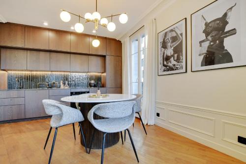 une cuisine avec une table et des chaises dans une pièce dans l'établissement Parisian Suites, à Boulogne-Billancourt