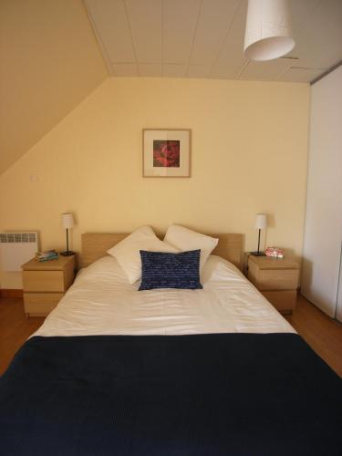 une chambre avec un grand lit blanc avec deux tables de nuit dans l'établissement Gîte Poire - Les Gîtes de la Lohuas, à Les Champs-Géraux