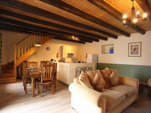 un salon avec un canapé et une table dans l'établissement Gîte Cerise - Les Gîtes de la Lohuas, à Les Champs-Géraux