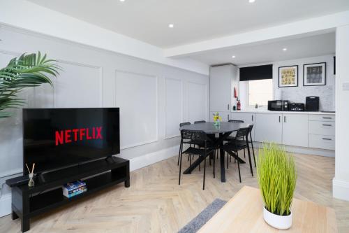 a kitchen and dining room with a table and a television at Modern 5 BED-2 BATH Apartment in Galashiels