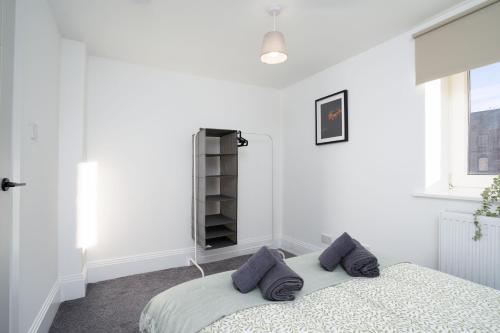 a bedroom with a bed with purple pillows on it at Modern 5 BED-2 BATH Apartment in Galashiels