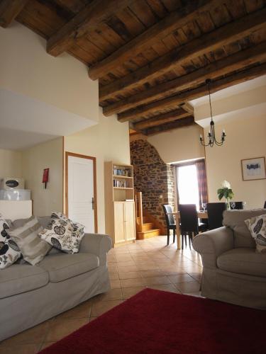 un salon avec deux canapés et une salle à manger dans l'établissement Gîte Abricot - Les Gîtes de la Lohuas, à Les Champs-Géraux