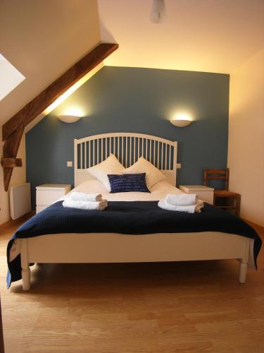 une chambre avec un grand lit avec un mur bleu dans l'établissement Gîte Abricot - Les Gîtes de la Lohuas, à Les Champs-Géraux