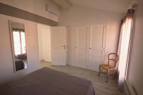 une chambre avec un lit, une chaise et un miroir dans l'établissement Belvédère, à Collioure