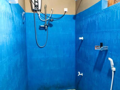 baño azul con ducha con pared azul en Sh li, en Sigiriya