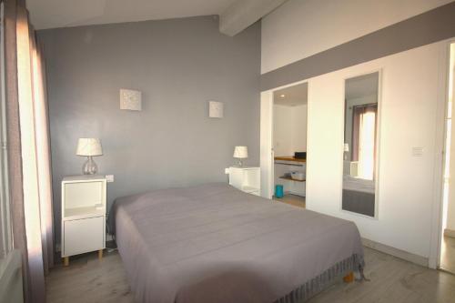 une chambre avec un grand lit et un miroir dans l'établissement Belvédère, à Collioure