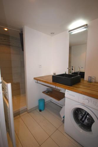 une salle de bain avec un lavabo et une machine à laver dans l'établissement Belvédère, à Collioure