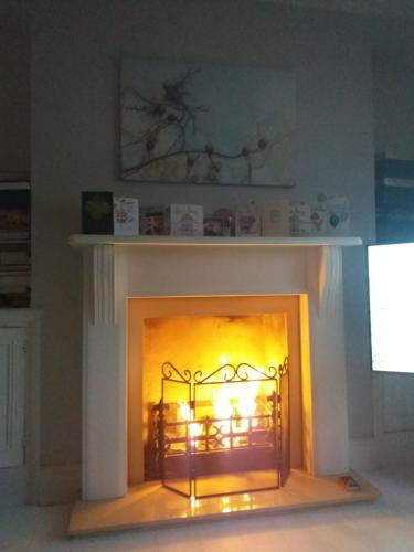 a fireplace with a yellow fire in it at What a view Mevagissey in Mevagissey