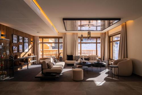 a living room with couches and chairs and windows at Résidence l'Ecrin d'Argent by My Mountain Resort in Valmorel
