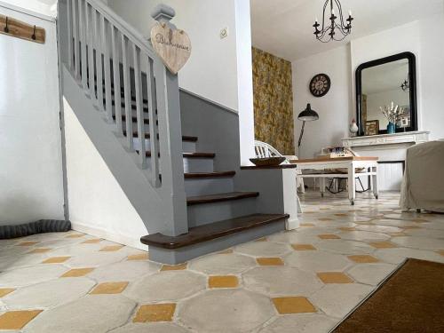 un salon avec un escalier et une table dans l'établissement Villa Petit Pierre, à Saint-Aubin-sur-Mer