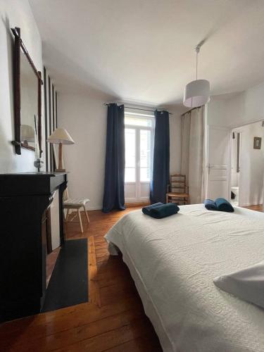 une chambre avec un grand lit avec des oreillers bleus dessus dans l'établissement Villa Petit Pierre, à Saint-Aubin-sur-Mer