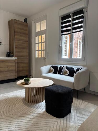 un salon avec un canapé et une table basse dans l'établissement Le Lodge, à Épernay