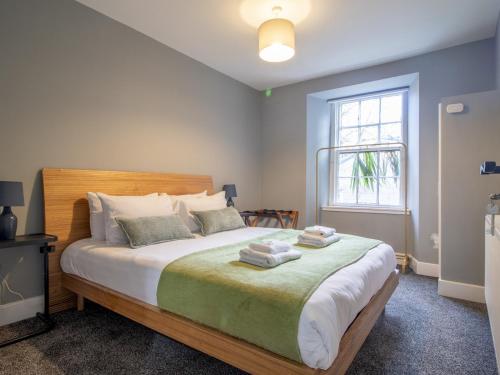 a bedroom with a large bed with towels on it at Pass the Keys Happy Haven Home, West End in Glasgow