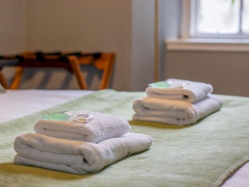 three folded towels sitting on top of a bed at Pass the Keys Happy Haven Home, West End in Glasgow