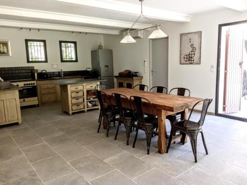 une grande cuisine avec une table et des chaises en bois dans l'établissement Maison de Charme avec piscine dans le Parc Naturel des Alpilles, à Saint-Rémy-de-Provence