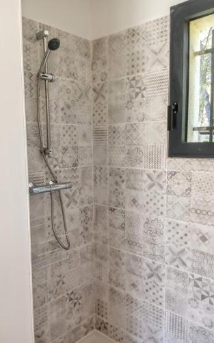 une douche dans une salle de bain avec un mur carrelé dans l'établissement Maison de Charme avec piscine dans le Parc Naturel des Alpilles, à Saint-Rémy-de-Provence
