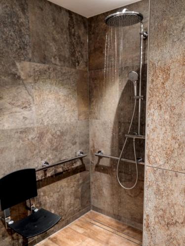 a shower with a shower head in a bathroom at Landresort MUHRHOF in Drachselsried