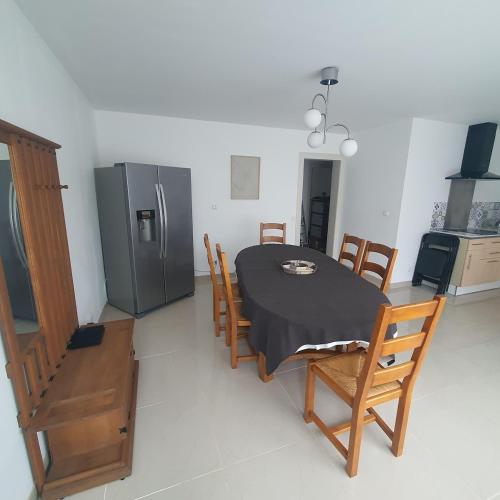 une cuisine avec une table et un réfrigérateur dans l'établissement Maison, à Ambrault