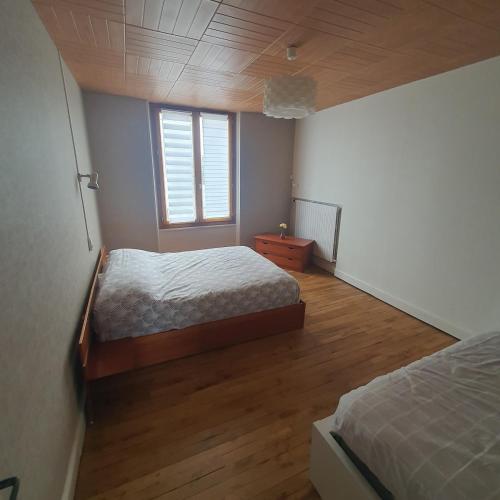 una camera da letto con due letti e una finestra di Maison a Ambrault