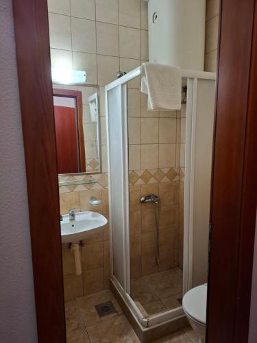 a bathroom with a shower and a sink and a toilet at Hotel Koliba na Grza in Kilsura