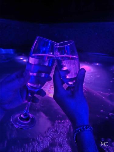 une personne détenant une paire de verres à vin dans l'établissement spa privatif Dydy's love saint amand les eaux, à Lecelles