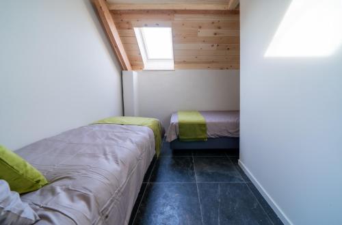 a small room with two beds and a window at Barabois luxury vacation home in Ronse