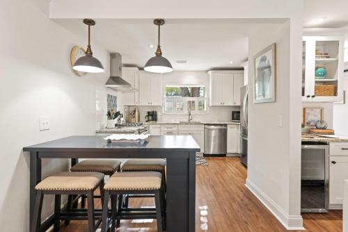a kitchen with a black island with stools at Tranquility - 4318 Tenth Street in Saint Simons Island
