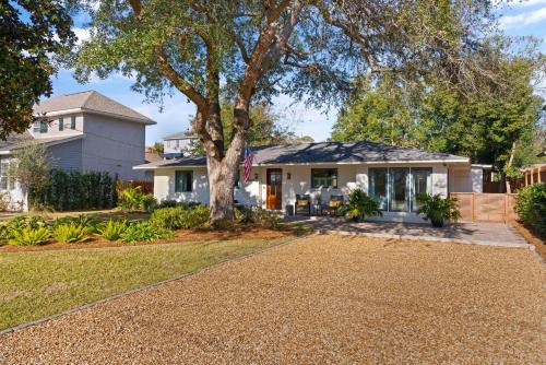 a house with a tree and a driveway at Tranquility - 4318 Tenth Street in Saint Simons Island