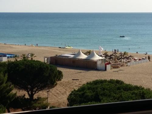 - une plage avec des tentes et l'océan en arrière-plan dans l'établissement T2 - devant la mer, à Argelès-sur-Mer